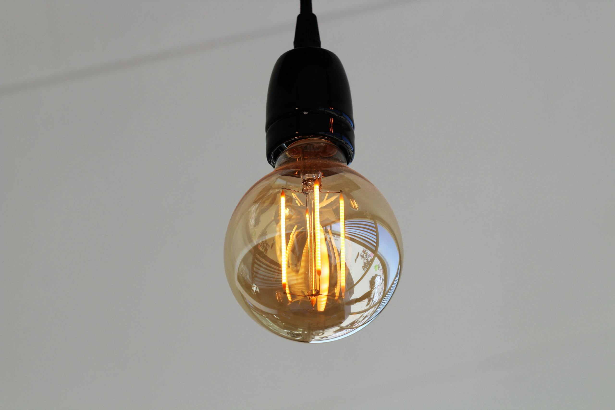 Close-up of a vintage Edison bulb with glowing filaments, showcasing classic tungsten lighting.