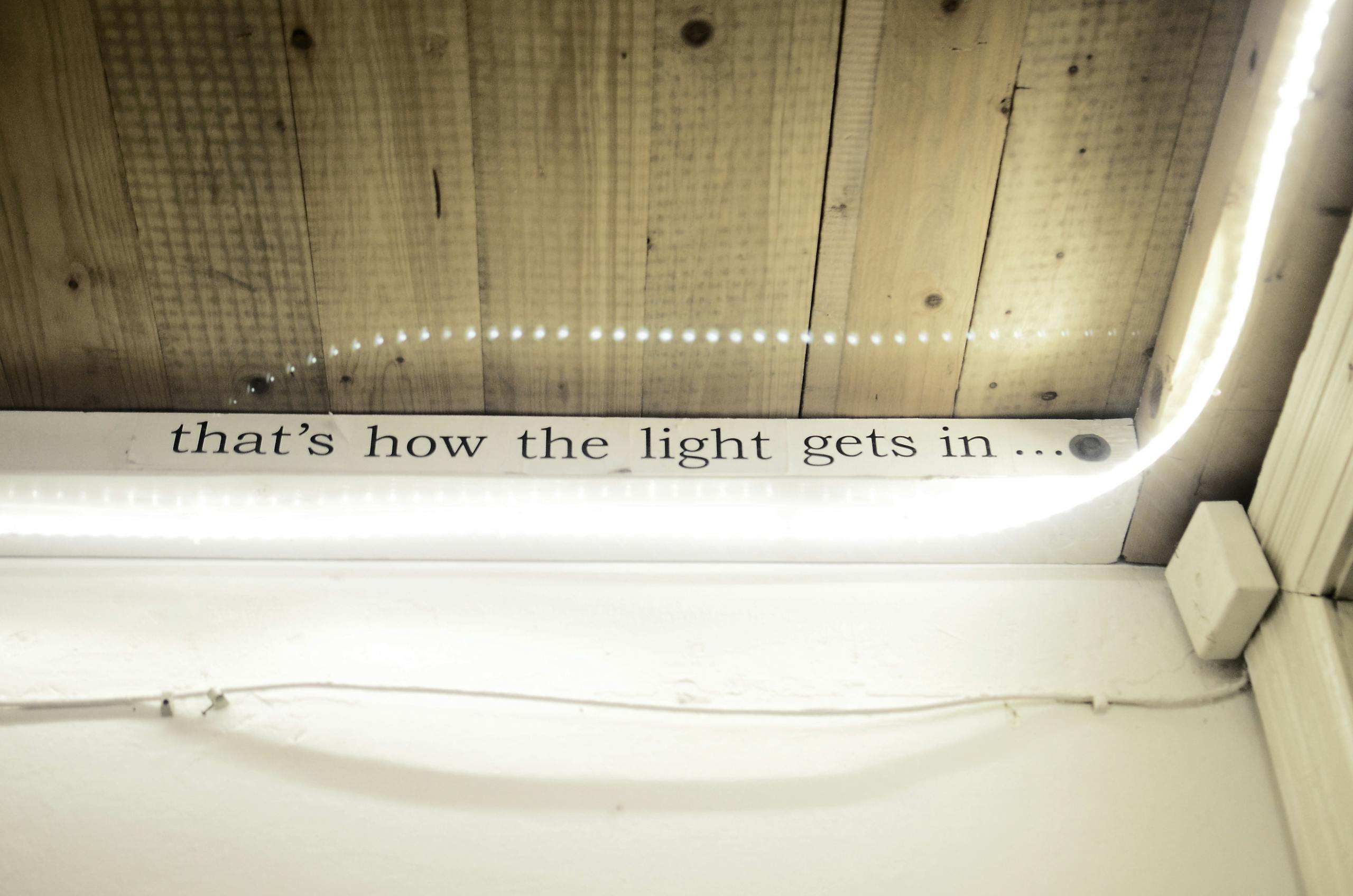 High angle of text written on window decorated with shiny lights reflecting in glass