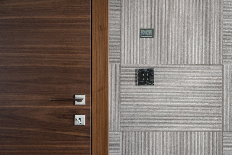 Sleek modern wooden door with stainless steel handle and 22.4°C display.