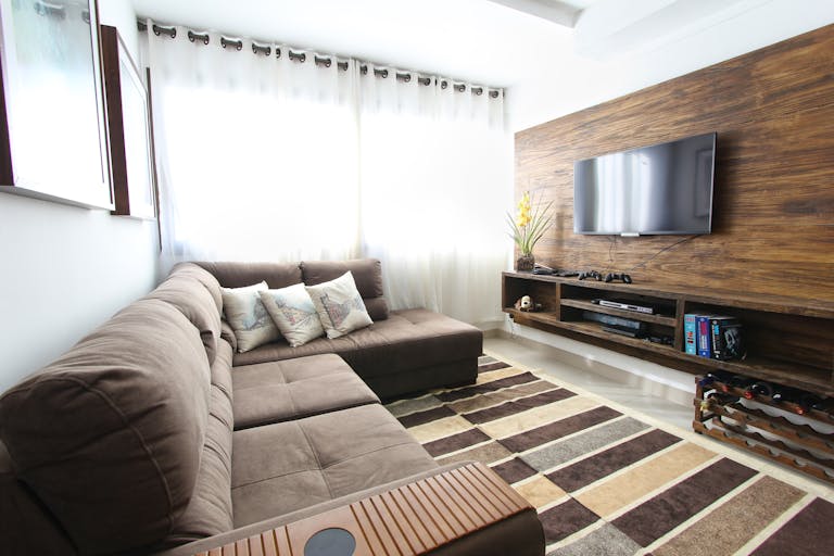 Stylish modern living room featuring a brown sofa, wall-mounted TV, and interior decor.